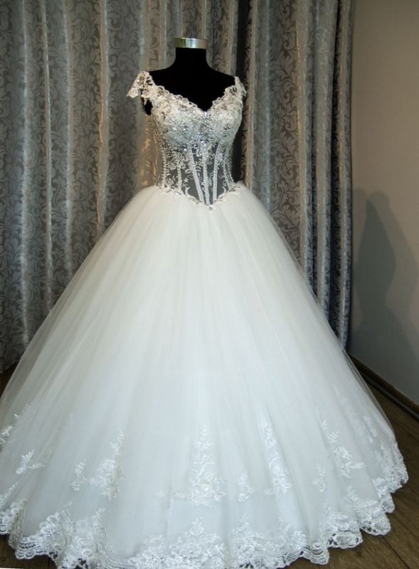 Пышное свадебное платье из многослойного фатина с кружевной отделкой.