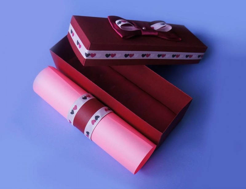 розовый свиток в красной дизайнерской упаковке